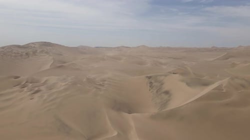 Aerial: Beautiful artistic desert sand dunes extend to distant horizon