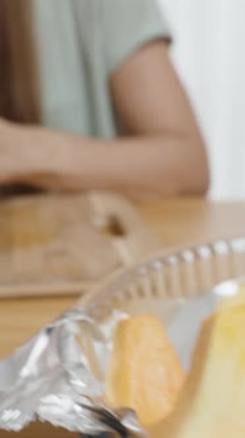 Vidéo verticale. Une femme épluche la peau d'une citrouille avec un couteau à légumes spécial
.