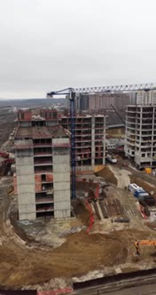 Vertical Aerial Drone Cinematic Approach Toward Residential Construction Site With Tower Crane