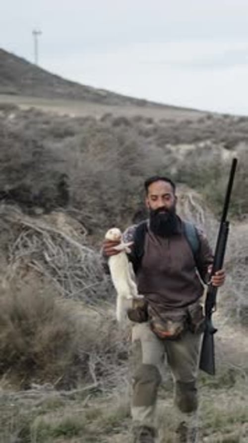 Un chasseur et son compagnon avec un furet blanc