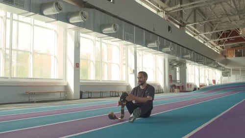 Man with Prosthetic Leg Removes Device on Track