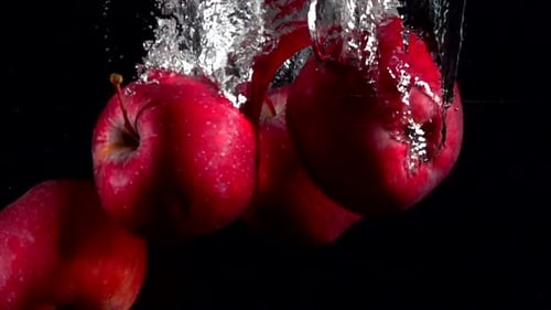 Slow Motion Red Apple Falling Underwater Water on Black Background