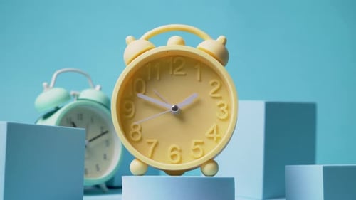 Yellow Alarm Clock on Blue Background Studio Shot