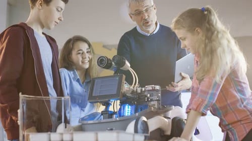 Der Lehrer und seine Schüler arbeiten an einem programmierbaren Roboter mit LED-Beleuchtung für die naturwissenschaftliche Klasse P