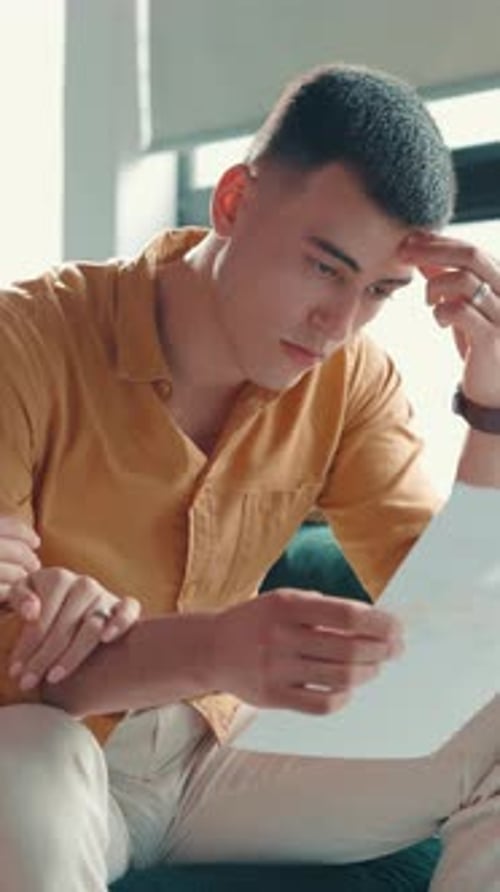 Stress, documents and comfort with man on sofa for foreclosure, joint account and bankruptcy