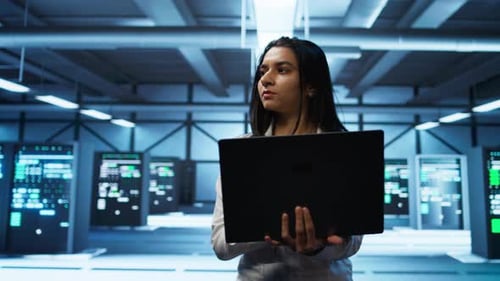 Young Adult with Laptop in a Server Room