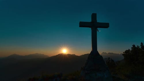 Cross On A Mountain Peak At Sunset