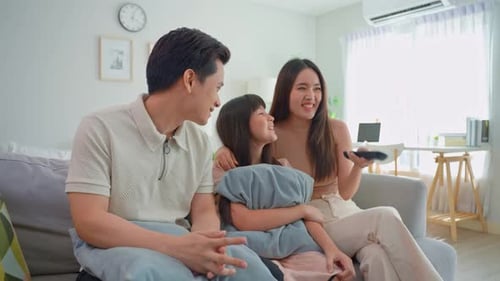 Family Laughing Together on the Couch at Home