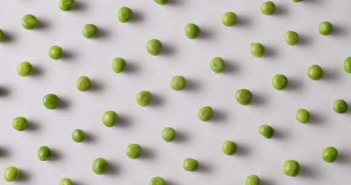 Fresh Green Peas Placed Side By Side Rotate on a White Platform