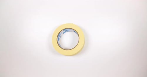 Round Masking Tape Spinning On White Table. - high angle