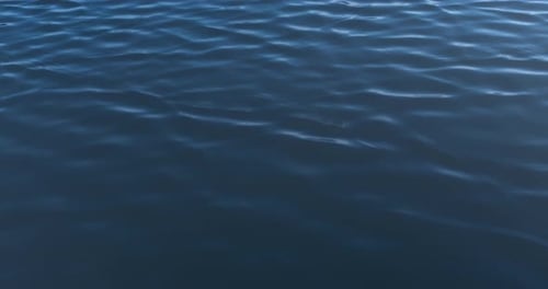 Blue lake surface glistening softly, symbolizing peace, clarity, and calm.