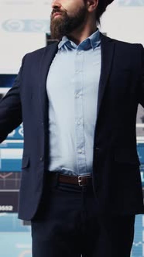 Businessman Stands in Front of Monitors and Gestures