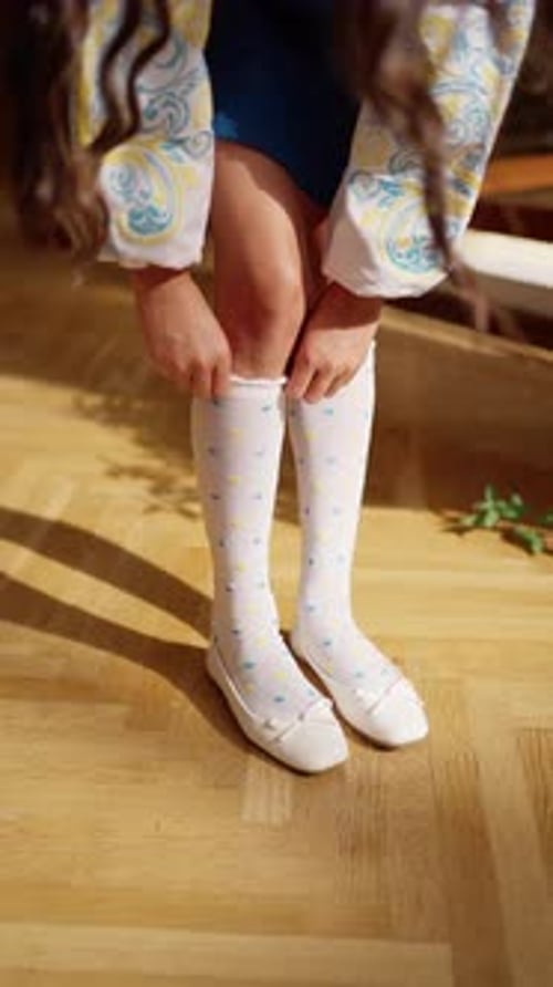 Child in White Socks Adjusts Them