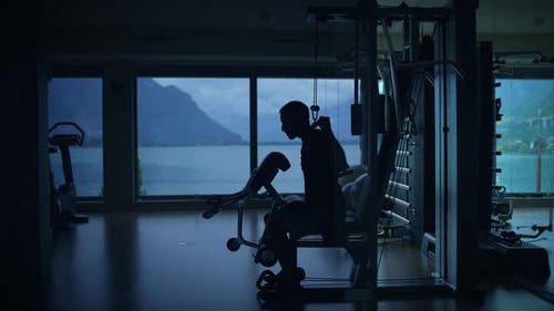 Silhouette of a Dedicated Athlete Engaging in a Vigorous Workout in a Beautiful Scenic Gym