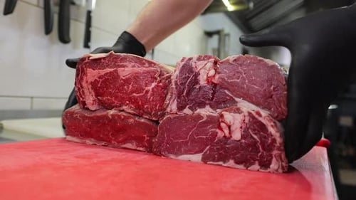Raw Red Beef Steaks Arranged on Cutting Board