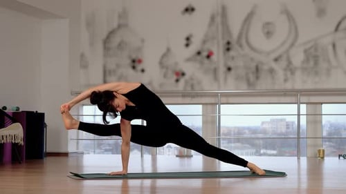 Femme faisant du yoga au studio, seule, pieds nus, femme effectuant des exercices de flexibilité debout