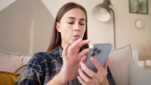 Woman Using Smartphone on Couch Indoors