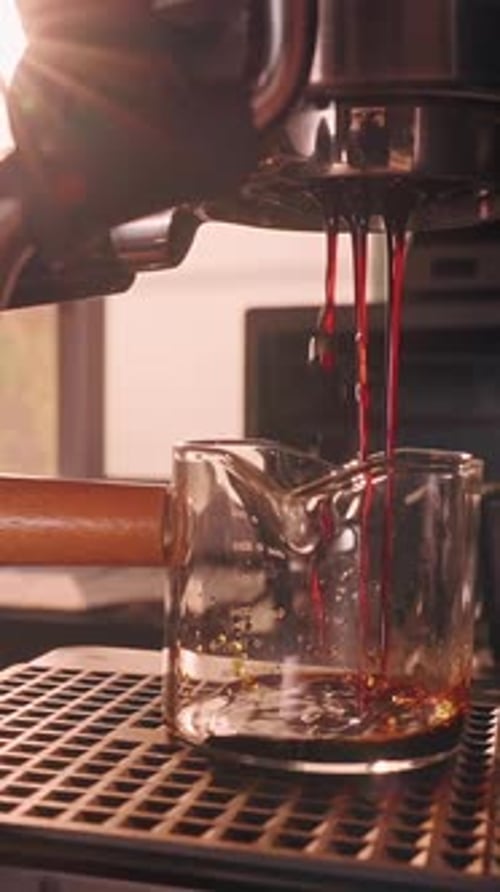 Vertical video. Incorrect Espresso Extraction in Slow Motion with Thin Uneven Coffee Stream from