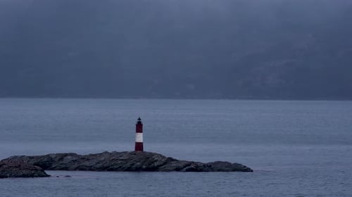 Wunderschöner Leuchtturm, der in der Antarktis vorbeisegelt, Kreuzfahrt in der stimmungsvollen blauen, bewölkten Abenddämmerung