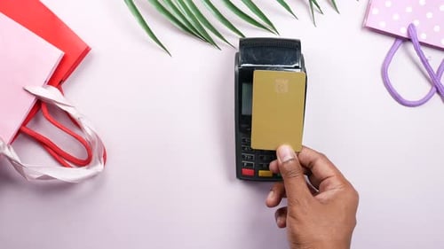 Hand Taps Credit Card on Payment Terminal