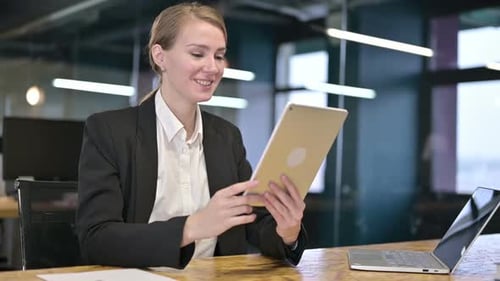 Young Businesswoman doing Video Chat on Tablet in Office