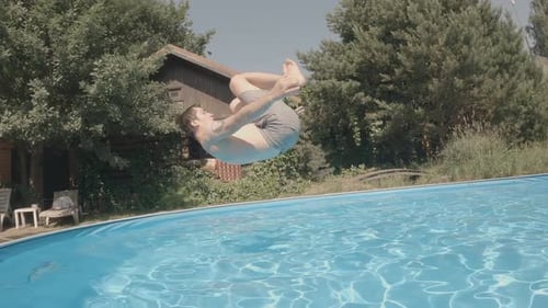 Teenager springt an einem heißen, sonnigen Tag ins Schwimmbad und macht Saltos, Wasserspaß, Unterwasseraufnahme