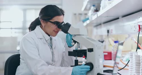 Smiling Scientist Examining Slides in a Laboratory