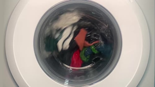 Funktionierende Waschmaschine in Zeitlupe. Waschmaschine funktioniert und dann fällt sie plötzlich aus und stoppt