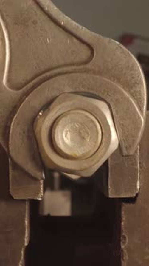Metal Wrench Tightening Nut in Extreme Close Up