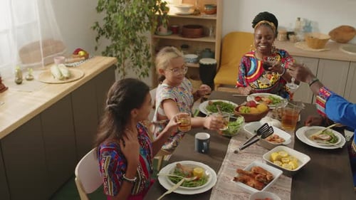 Family Mealtime Celebration with Raised Glasses at Home