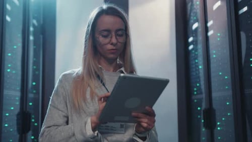 Woman Uses Tablet in Data Center Server Room