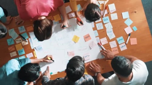 Top view of skilled project manager writing and sticking stick notes. Symposium.