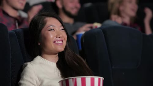 Une fille joyeuse exprime ses émotions tout en appréciant un mélodrame