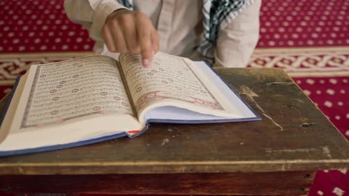 Concept de prière islamique L'homme musulman étudie attentivement le Saint Coran et prie Allah dans la mosquée