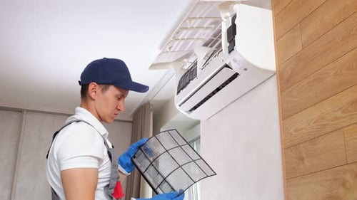 Technician Changing Air Conditioner Filter Indoors