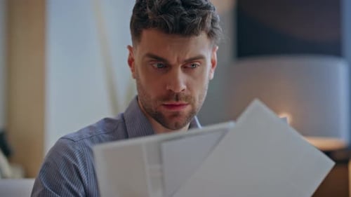 Man Reviews Documents Indoors, Close Up