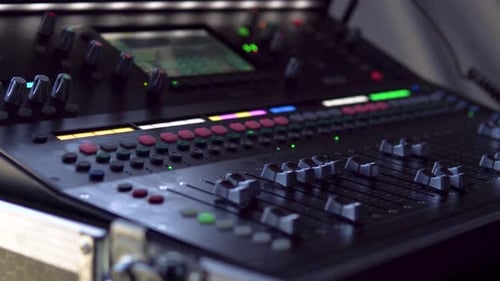 A close-up of a live audio mixer, with precise sound adjustments being made. Perfect for showcasing
