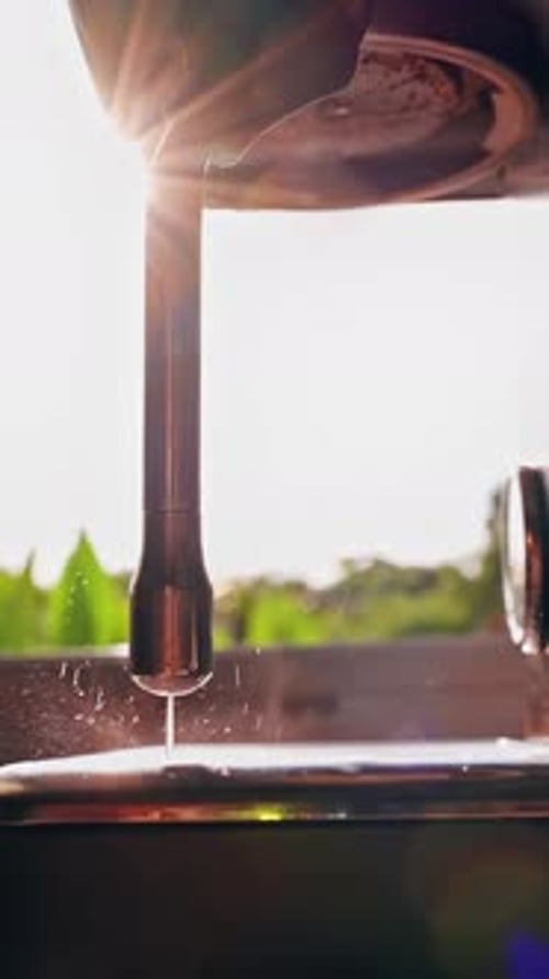 Vertical video. Close Up Low Angle View Steam Wand Rinsing With Water Dripping Into Drip Tray Under