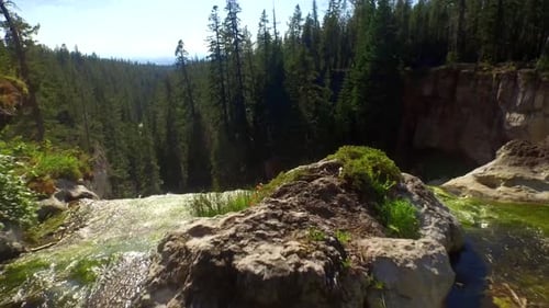 Drone follows Oregon waterfall cascading to adventurous people in refreshing waters