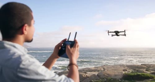 4k video footage of a young man flying a drone at the beach