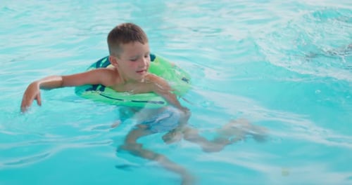 Funny Happy Child Boy in Swimming Pool on Inflatable Rubber Circle Ring