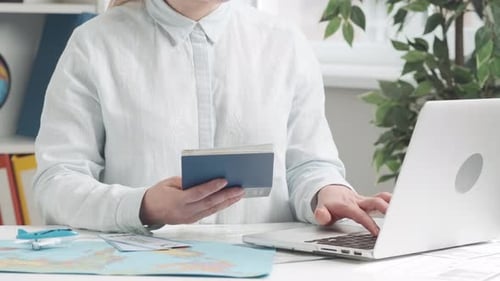 A Travel Agent Typing on a Laptop Keyboard