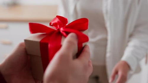 Man Giving a Gift to a Woman in Kitchen