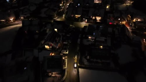 Slow flight over american housing area with warm lights during snowy winter night. Christmas decorat