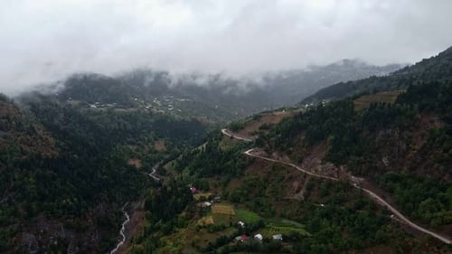 Tal mit einer Straße, die sich durch Wolken schlängelt