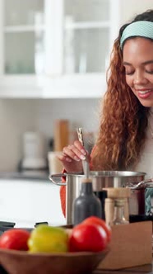 Young Woman Cooking in Kitchen Stirs Pot