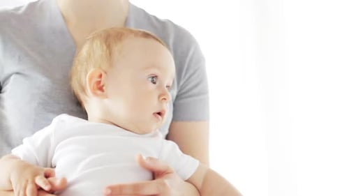 Adorable Infant Being Held by Adult Indoors