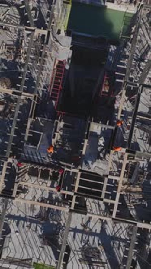 Vertical Video of Workers Laying Concrete Foundations and Assembling Walls on a Construction Site