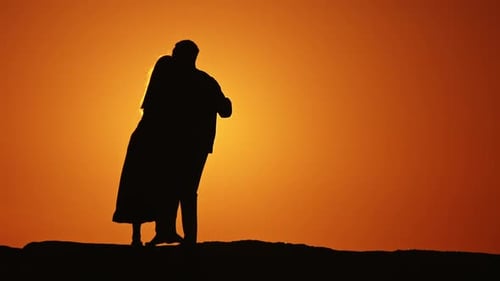 Romantic Couple Embracing at Golden Sunset Silhouette