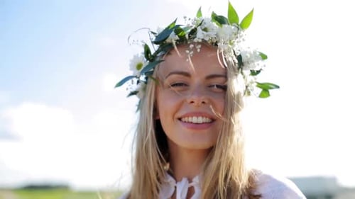 Smiling woman with flower crown in the sun